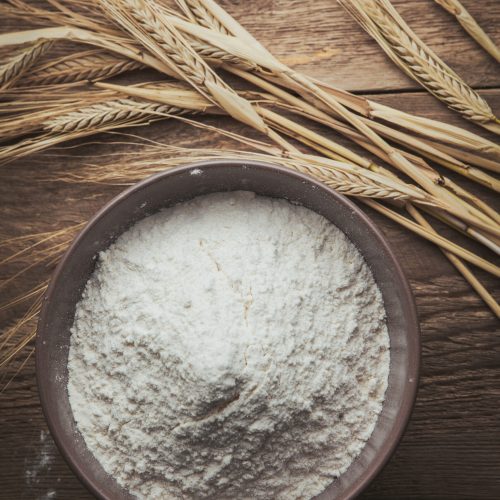 Flour and wheat flat lay on a wooden background